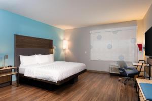 a hotel room with a bed and a desk and a chair at Tru By Hilton Ashland, Va in Ashland