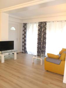 sala de estar con sofá amarillo y TV en Tourelle, en Gagny