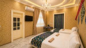 a hotel room with two beds and a chandelier at Sole Family Guesthouse in Samarkand