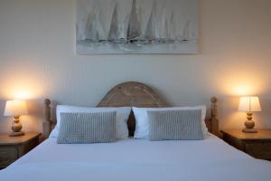 a bedroom with a white bed with two lamps at Landhotel Strandallee in Wunstorf