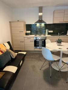 a living room with a couch and a table and a kitchen at Casa Sandra Elisa - Studio aan water in Maasmechelen