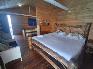 a bedroom with a bed in a wooden room at Hotel Isla Gaviota in Tintipan Island