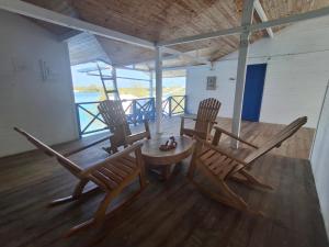 a dining room with three chairs and a table at Hotel Isla Gaviota in Tintipan Island
