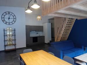 a living room with a table and a blue couch at Auberge des Fées in Buttes