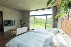 a bedroom with a white bed and a television at G.bouquet in Nakijin