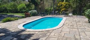 a swimming pool in a patio with chairs and a table at Flat 02 Carvalhos de Aldeia in Recife