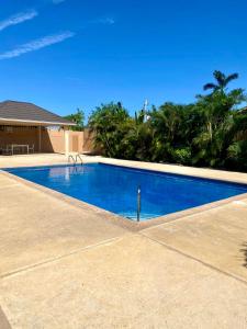 a large blue swimming pool in front of a house at Palm Retreat in Ocho Rios