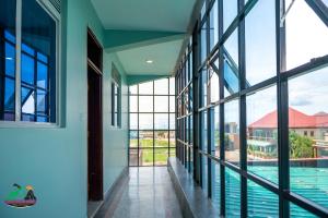 a corridor of a building with windows and a swimming pool at Legacy Chillout Kasese in Kasese
