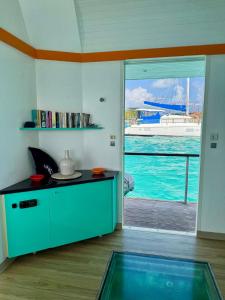 a kitchen with a view of a boat in the water at Lagoon Lodge Caraïbes -Lodge flottant sur lagon avec vue mer in Saint-François