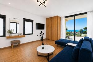 a living room with a blue couch and a table at Nobile Boutique Hotel in Agios Gordios
