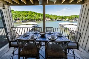 a table on a balcony with a view of a marina at Sunset Lakefront Retreat with Luxe Upgrades in Osage Beach