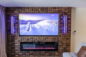 a television on a brick wall with a fireplace at Sunset Lakefront Retreat with Luxe Upgrades in Osage Beach
