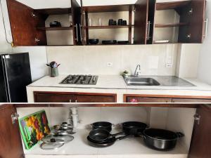 a small kitchen with a stove and pots and pans at Acogedor apartamento in Leticia