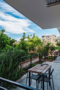 a wooden table and chairs on a balcony at Villa Myrtaj - Luxury Private Pool in Sarandë
