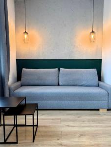 a blue couch in a living room with a table at BOOGIE Home Kamienica Łódzka in Łódź