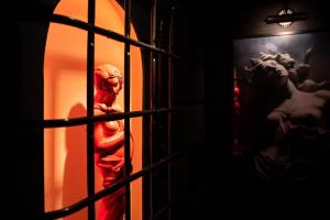 a statue is seen through a barred window at La Suite de Vénus - Chambre à thème Love Room Jacuzzi et Pièce Secrète - Évasion pour deux in Schirrhein