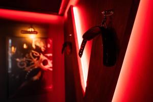 a red door with a phone hanging from it at La Suite de Vénus - Chambre à thème Love Room Jacuzzi et Pièce Secrète - Évasion pour deux in Schirrhein