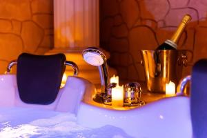 a bathroom sink with a bottle of wine in a bucket at La Suite de Vénus - Chambre à thème Love Room Jacuzzi et Pièce Secrète - Évasion pour deux in Schirrhein +41 photos