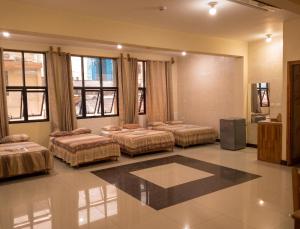 a room with three beds and a television in it at Casa Nativa Iquitos in Iquitos