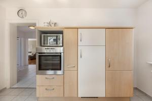 a kitchen with wooden cabinets and a white refrigerator at K8 Living in Wehr