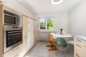 a kitchen with a table and a microwave and a window at K8 Living in Wehr +15 photos