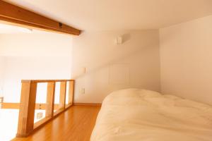 a bedroom with a bed and a wooden floor at 森のオフィス Living in Fujimi