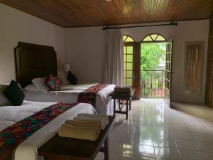 a hotel room with two beds and a balcony at Hacienda Escondida 10min to Airport in Alajuela +50 photos