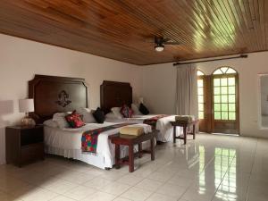 a bedroom with two beds and a wooden ceiling at Hacienda Escondida 10min to Airport in Alajuela