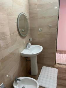 a bathroom with a sink and a mirror and a toilet at Nesti house in Orikum +6 photos