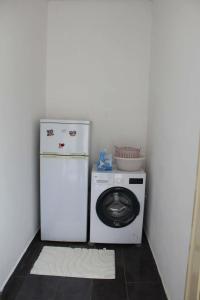 a small kitchen with a washing machine and a washer at Nesti house in Orikum