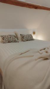a white bed with two pillows on top of it at Maison Auguste - cosy - terrasse in Verberie