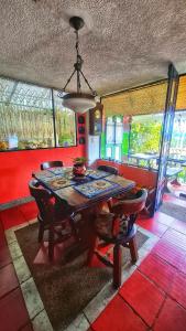 a dining room with a table and chairs and a chandelier at El Pedregal Sopó in Sopó