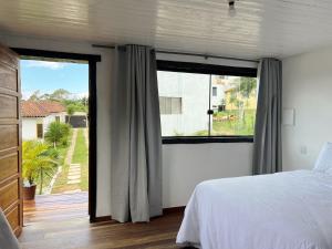 a bedroom with a bed and a large window at Villa Salgueiro in Lavras Novas