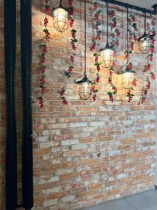 a brick wall with lights and flowers on it at BOOGIE Home Kamienica Łódzka in Łódź