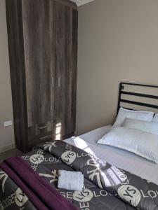 a bed with a wooden headboard in a bedroom at Maneya Apartments in Kabwe