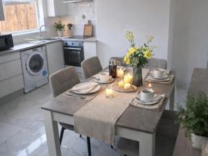 a kitchen with a table and chairs with candles on it at Three-Bedroom House Perfect for Contractors and Small Groups, sleeps 5 people in Durham in Bishop Auckland