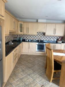 a kitchen with wooden cabinets and a wooden table and a table and a tablektop at The Clady Home in Clady