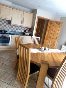 a kitchen with a wooden table and wooden chairs at The Clady Home in Clady