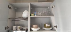 a cupboard with dishes and other items in it at Ocean and Mountain View T2 N-3 in Lazareto