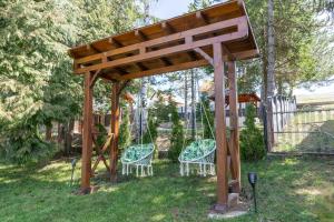 a wooden gazebo with two chairs and a swing at Vila Paradiso in Zlatibor