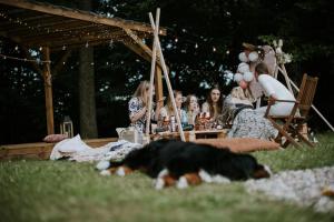 a group of people sitting at a table with a dog at Trzy Siostry Udryn in Udryń