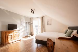 a bedroom with a bed and a tv and a window at Landhotel Strandallee in Wunstorf