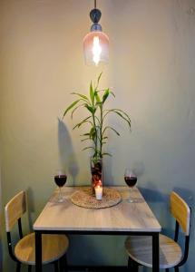 a table with a plant and two glasses of wine at Quincho's Place in Santa Ana