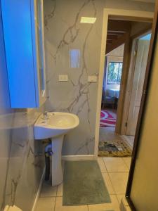 a bathroom with a sink and a marble wall at Cabañas Vistas al Río Villarrica in Villarrica +47 photos