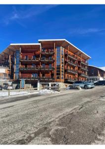 a large apartment building in the middle of a parking lot at Appartement, 6 pers Casserousse 310 in Chamrousse
