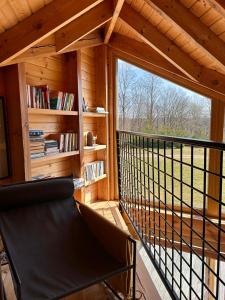 a room with a balcony with a chair and a window at Trzy Siostry Udryn in Udryń