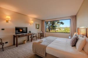 a hotel room with a bed and a desk and a window at Hotel Puerta del Sur in Valdivia