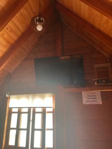 a flat screen tv in a room with a door at Chalé do Carlos in Ibiúna