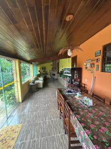 a living room with a long table in a room at Chalé do Carlos in Ibiúna