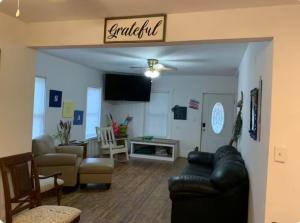 a living room with a black leather couch and a living room at The Pearl in Fort Walton Beach